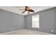 This bedroom features neutral walls, carpet flooring, and a ceiling fan at 556 Poplar Bnd, Canton, GA 30114