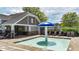 The zero entry wading pool and building, is surrounded by lush landscaping, lounge chairs, tables, and umbrellas at 556 Poplar Bnd, Canton, GA 30114