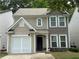 Inviting two-story home featuring neutral siding, a well-kept lawn, and an attached garage at 556 Poplar Bnd, Canton, GA 30114