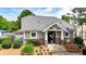 Exterior view of the pool house with stone accents, professional landscaping, and pool in the background at 556 Poplar Bnd, Canton, GA 30114