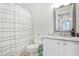 Bright bathroom featuring a shower with striped curtain and a vanity with granite countertop at 1303 Wingate Way, Atlanta, GA 30350