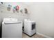 Functional laundry room with modern white washer and dryer appliances on tile floor at 1622 Honeysuckle Path, Conyers, GA 30012