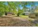 Backyard with a grassy area, mature trees, and storage sheds at 2664 Olive Springs Se Rd, Marietta, GA 30060