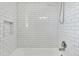 Updated shower featuring white subway tile, a built-in niche, and modern fixtures enhancing the bathroom's aesthetic appeal at 2664 Olive Springs Se Rd, Marietta, GA 30060