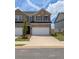 Brick townhouse featuring a two-car garage and a well-maintained front yard at 867 Pensive Run, Dacula, GA 30019