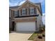 Charming brick townhouse showcasing a two-car garage and manicured landscaping at 867 Pensive Run, Dacula, GA 30019