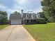 Charming brick home with a manicured lawn, dormer windows, and a long driveway at 1012 Gloria Grand Blvd, Mcdonough, GA 30252