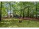 Landscaped backyard with mature trees and a fire pit, creating a peaceful retreat with nature views at 3927 Collier Nw Trce, Kennesaw, GA 30144