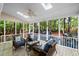 Screened patio with blue wicker furniture, ceiling fan, and natural views to the outside at 3927 Collier Nw Trce, Kennesaw, GA 30144