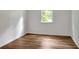 A bedroom featuring hardwood floors and a window, providing natural light and a view to the outside at 4368 Heritage Glen Ct, Marietta, GA 30068