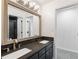 Bathroom with gray granite double sink vanity, large mirror, and door to walk-in shower at 5041 Corinault Nw Pl, Acworth, GA 30101
