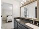 Modern bathroom featuring a double vanity with dark cabinets, gray countertop, and an illuminated mirror at 5041 Corinault Nw Pl, Acworth, GA 30101