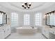 Elegant bathroom featuring double vanity, a soaking tub with bright windows, and a modern chandelier at 5041 Corinault Nw Pl, Acworth, GA 30101