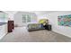 Bright bedroom with neutral carpet, a window view, a patterned comforter, and a decorative world map at 5041 Corinault Nw Pl, Acworth, GA 30101