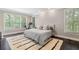 Cozy bedroom featuring dark floors, a shag rug, and large windows, offering comfort and natural light at 5041 Corinault Nw Pl, Acworth, GA 30101