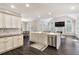 Open concept kitchen with white cabinets, island seating, stainless steel appliances, flows to living area at 5041 Corinault Nw Pl, Acworth, GA 30101