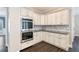 Gourmet kitchen features stainless steel appliances, white cabinetry, granite counters, and stylish backsplash at 5041 Corinault Nw Pl, Acworth, GA 30101