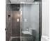 Stylish shower with herringbone pattern tile and sleek glass door, showcasing modern bathroom design at 5041 Corinault Nw Pl, Acworth, GA 30101