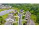 Aerial view of a residential neighborhood featuring a pond, green spaces, and neatly arranged homes at 6390 Yellow Birch St, Cumming, GA 30040