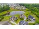 Aerial view of an upscale neighborhood with well-manicured lawns and a central pond with a fountain at 6390 Yellow Birch St, Cumming, GA 30040