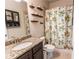 Well-lit bathroom featuring granite countertop and shower with patterned curtain at 6390 Yellow Birch St, Cumming, GA 30040