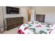 A comfortable bedroom features an entertainment center and a bed with a white and red cover at 6390 Yellow Birch St, Cumming, GA 30040