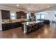 This kitchen features a large island with granite countertops and stainless steel appliances at 6390 Yellow Birch St, Cumming, GA 30040