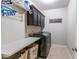 Laundry room with front load washer and dryer, cabinetry, and a folding table at 6390 Yellow Birch St, Cumming, GA 30040