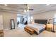 Large primary bedroom with a tray ceiling, ceiling fan and a sitting area providing ample space to unwind at 6390 Yellow Birch St, Cumming, GA 30040
