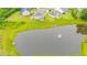 An aerial view of neighborhood houses and green space surrounding a large pond with a water feature at 6390 Yellow Birch St, Cumming, GA 30040