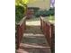 Backyard features a wooden bridge leading to a green lawn and a house with a staircase visible in the background at 1270 Heritage Lakes Dr, Mableton, GA 30126