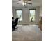 Bright bedroom featuring neutral walls, carpet, windows, and a ceiling fan with lights at 1270 Heritage Lakes Dr, Mableton, GA 30126