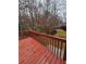 A wooden deck and railing with views of the backyard treescape and a glimpse of a neighboring home at 1270 Heritage Lakes Dr, Mableton, GA 30126