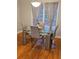Modern dining room with a glass table, upholstered chairs, hardwood floors, and natural light at 1270 Heritage Lakes Dr, Mableton, GA 30126