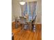 Modern dining room with a glass table, upholstered chairs, hardwood floors, and natural light at 1270 Heritage Lakes Dr, Mableton, GA 30126