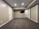 Spacious carpeted basement with two doors and mounted television at 2785 Old Sewell Rd, Marietta, GA 30068