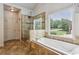 A luxurious bathroom features a soaking tub, glass-enclosed shower, and neutral tile at 2785 Old Sewell Rd, Marietta, GA 30068