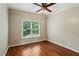 Bedroom with hardwood floors, ceiling fan, and large window providing natural light and a pleasant view at 2785 Old Sewell Rd, Marietta, GA 30068
