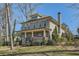 Charming two-story home with a large front porch is nestled among mature trees at 2987 Jefferson St, Atlanta, GA 30341
