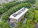 Aerial view shows building surrounded by lush green trees with parking below at 319 Atlanta Se St # 315, Marietta, GA 30060