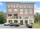 Exterior shot of a brick condo building with arched windows and parking at 319 Atlanta Se St # 315, Marietta, GA 30060