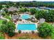 Aerial view of resort-style community pools, tennis courts, clubhouse surrounded by lush greenery at 3750 Sweeting St, Cumming, GA 30041