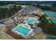 Aerial view of community amenities with pools, tennis courts, and clubhouse nestled among green trees at 3750 Sweeting St, Cumming, GA 30041