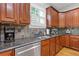 Close-up of a well-equipped kitchen with dark cabinetry, stainless steel appliances, and granite countertops at 3750 Sweeting St, Cumming, GA 30041