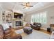Cozy living room with stone fireplace, built-in shelves, coffered ceiling, and leather furniture at 3750 Sweeting St, Cumming, GA 30041