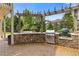 Outdoor kitchen boasts stone surround with built in grill station and beautiful lighting for enjoyable outdoor cooking at 3750 Sweeting St, Cumming, GA 30041