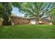 Expansive backyard with lush green grass, mature trees, a brick house, and a screened-in porch at 500 Read Ln, Atlanta, GA 30328