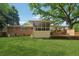 Backyard of a brick home featuring a covered back porch, deck, and spacious grassy area, perfect for entertaining at 500 Read Ln, Atlanta, GA 30328