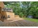 Inviting backyard featuring a large wooden deck, lush greenery, wooden fence, and storage shed at 500 Read Ln, Atlanta, GA 30328