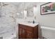 Bathroom featuring a marble shower with glass door, modern fixtures, and a dark wood vanity at 500 Read Ln, Atlanta, GA 30328